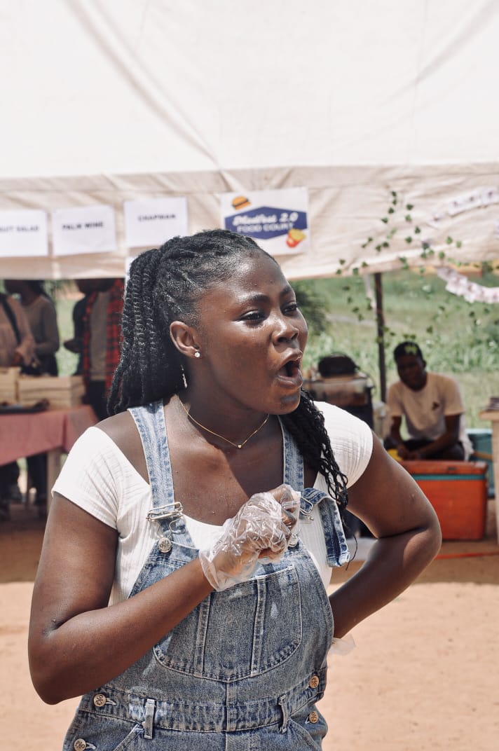 A guest cheering beside a festival stall